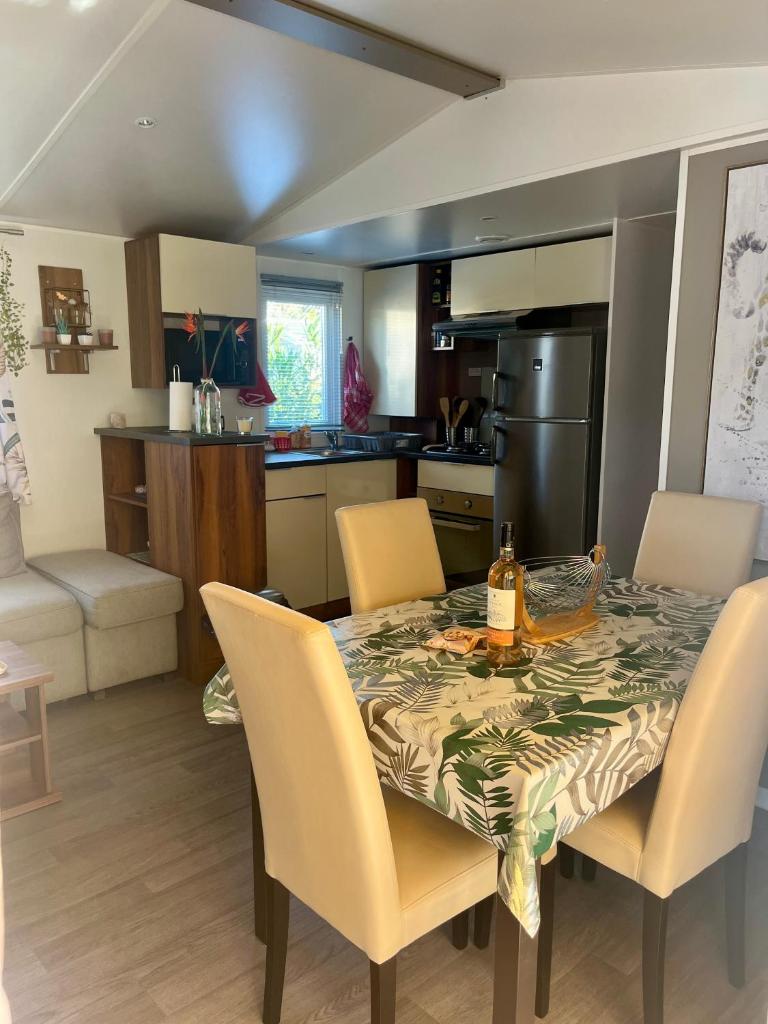 Il dispose d'une cuisine avec une table et des chaises. dans l'établissement Mobile home exotique de 40 m2, à Fréjus
