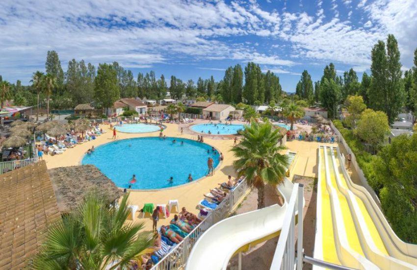 une grande piscine dans un complexe hôtelier avec un toboggan dans l'établissement Mobile home exotique de 40 m2, à Fréjus