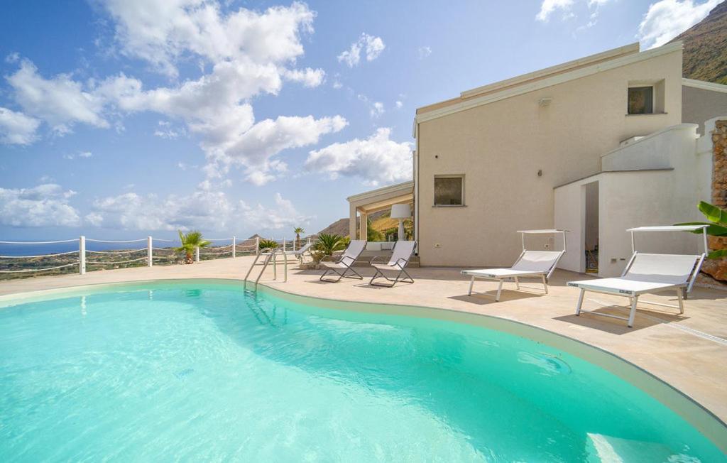 une grande piscine avec des chaises et un bâtiment dans l'établissement Villa Chicos with Panoramic Private Pool, à Castellammare del Golfo