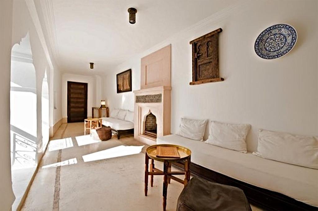 un salon avec un canapé et une cheminée dans l'établissement Riad Porte Royale, à Marrakech