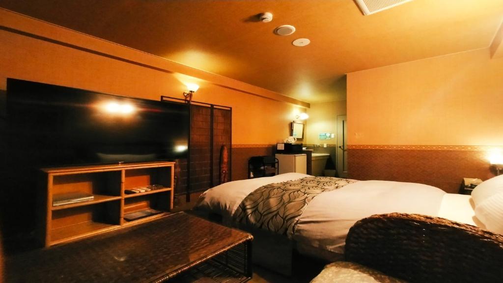 une chambre d'hôtel avec deux lits et une télévision à écran plat dans l'établissement Hotel Wave大人専用, à Hiroshima