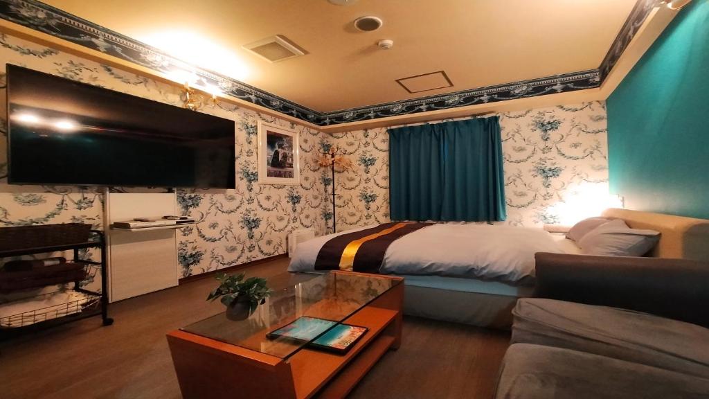 une chambre d'hôtel avec un lit et un canapé dans l'établissement Hotel Wave大人専用, à Hiroshima