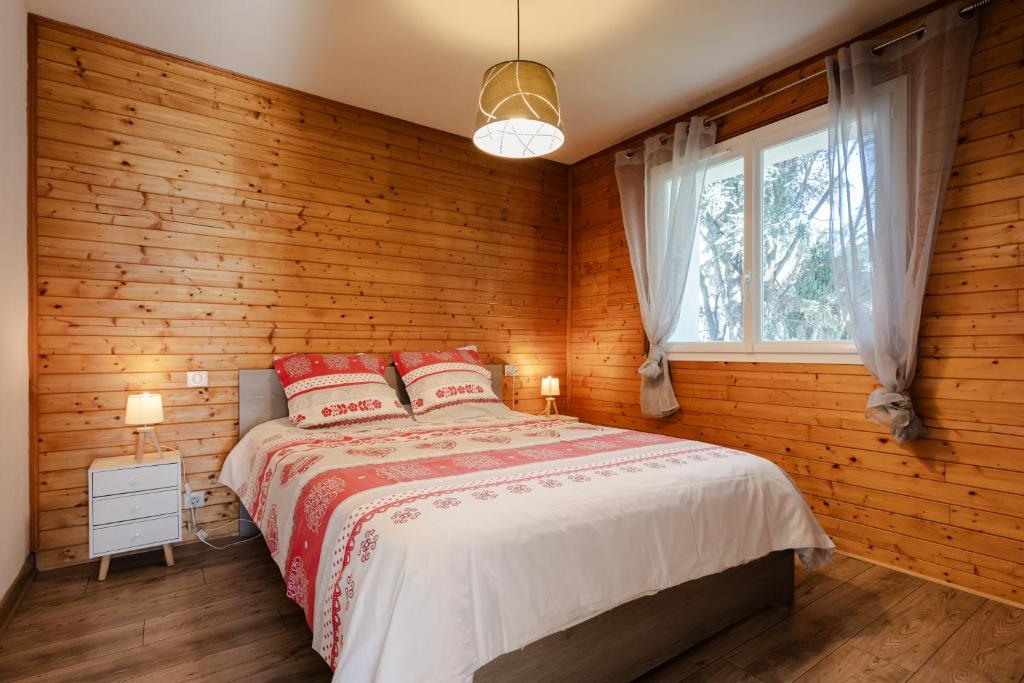 une chambre avec un lit avec des murs en bois et une fenêtre dans l'établissement Grand Gîte Saint-Lary centre pour 15 pers. pouvant accueillir jusqu’à 17 pers., à Saint-Lary-Soulan 12 autres photos