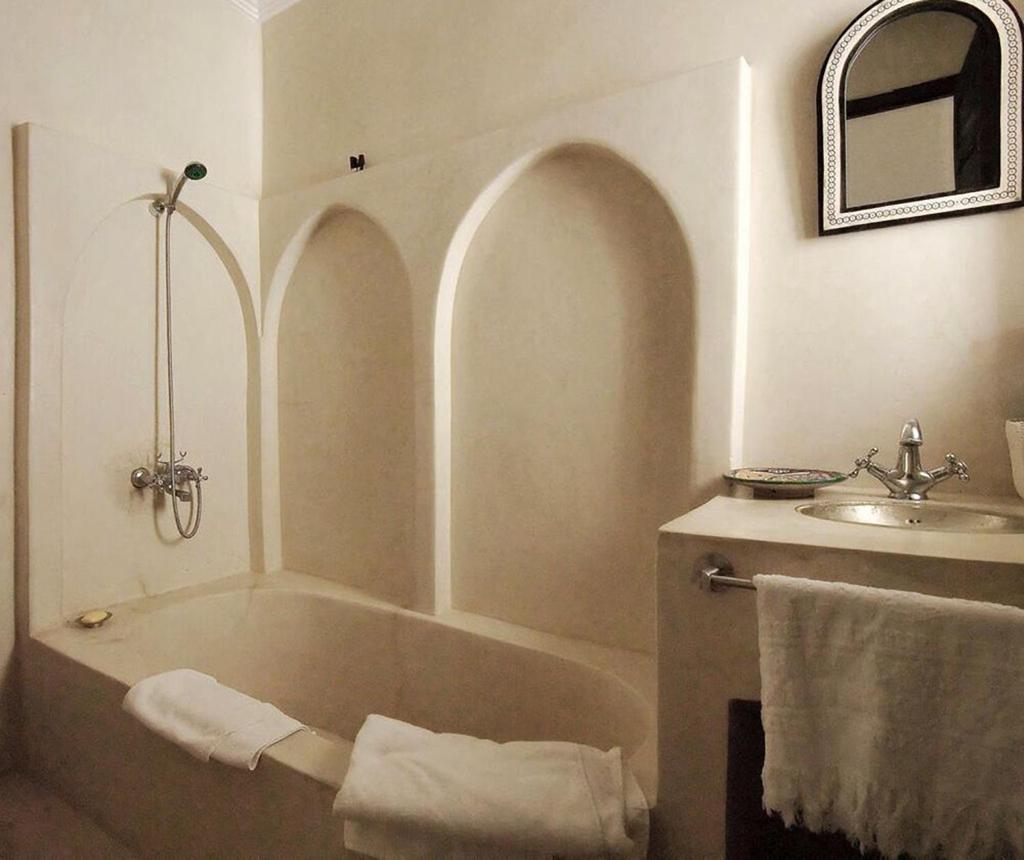 une salle de bain avec une baignoire et un lavabo dans l'établissement Riad Porte Royale, à Marrakech