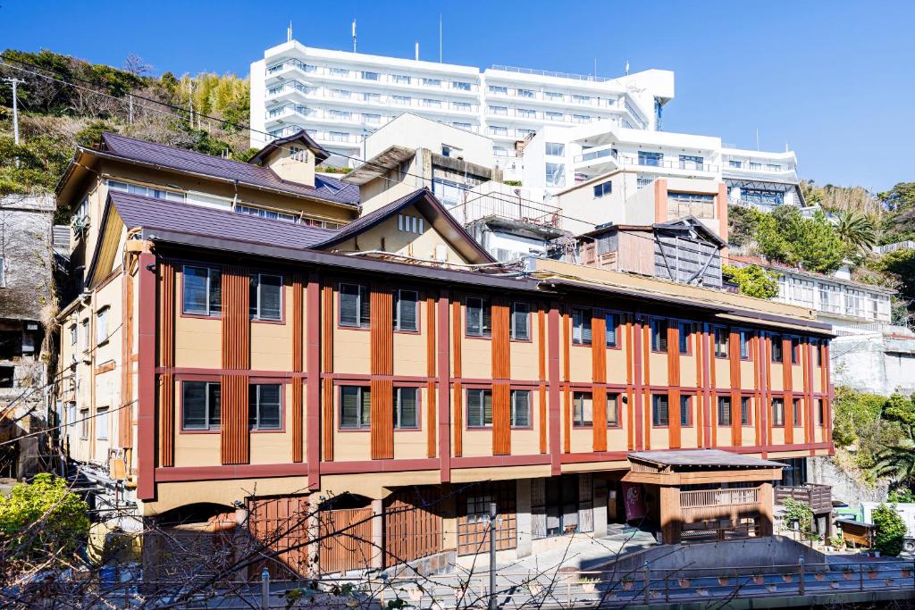 un bâtiment à flanc de montagne dans l'établissement Izu atagawa Yubana mankai -Adult Only-, à Higashiizu