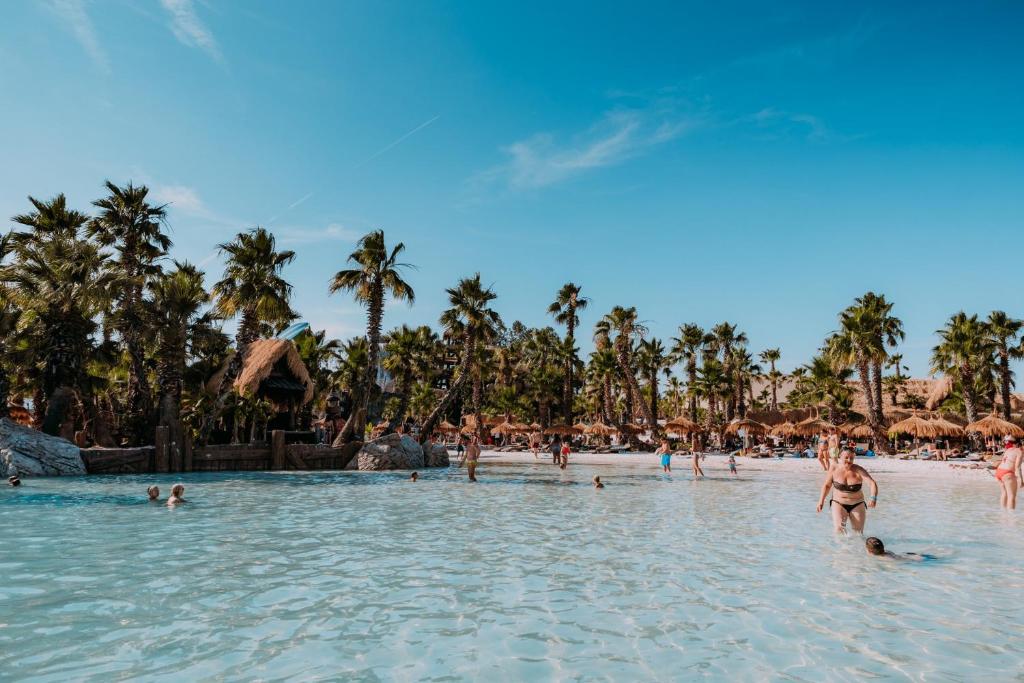 un groupe de personnes dans l'eau sur une plage dans l'établissement Hotel Edelweiss, à Lido di Jesolo