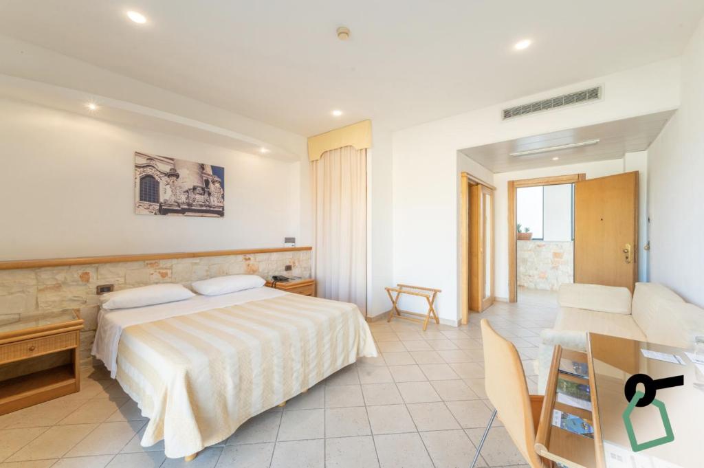 une chambre d'hôtel avec un lit et un bureau dans l'établissement HOTIDAY Leuca Lungomare, à Leuca