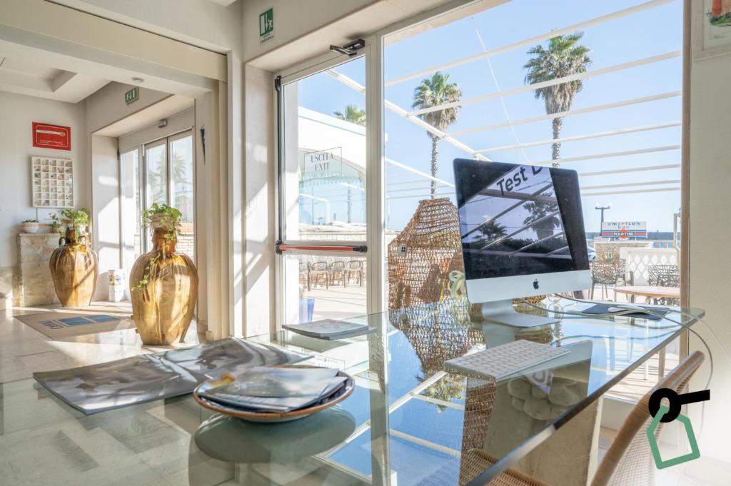Cette chambre dispose d'une table en verre avec un ordinateur. dans l'établissement HOTIDAY Leuca Lungomare, à Leuca