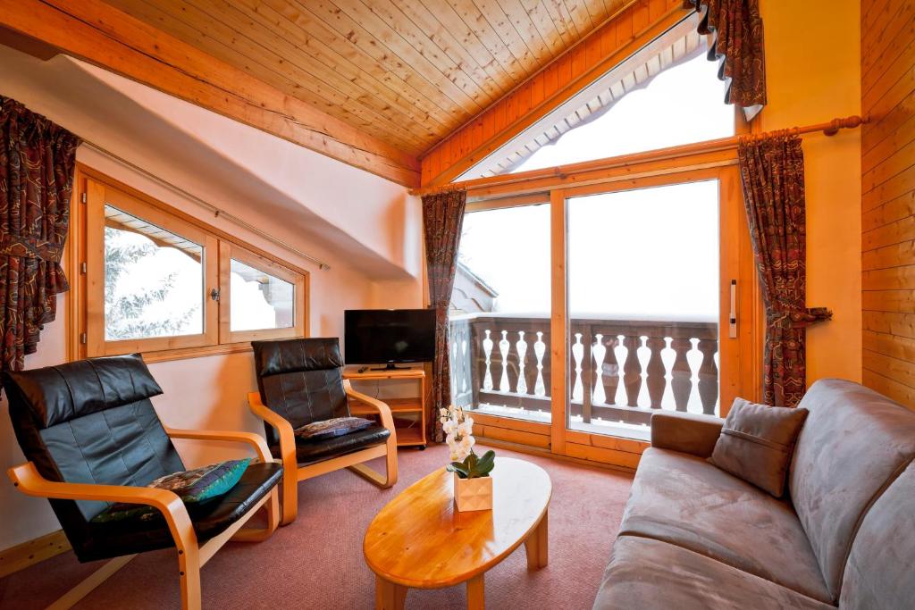un salon avec un canapé et une table dans l'établissement Hotel les Flocons, à Courchevel
