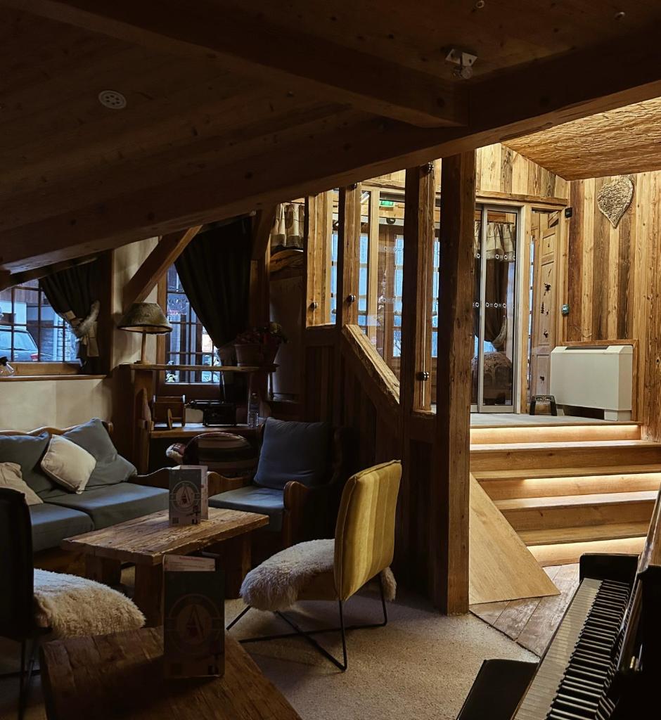 - un salon doté de meubles et d'un piano dans l'établissement le A by neige et roc, à Morzine