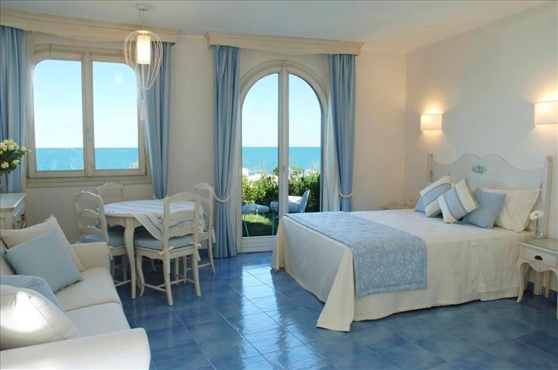 une chambre avec un lit, une table et des chaises dans l'établissement Baia Delphis Resort, à Vasto