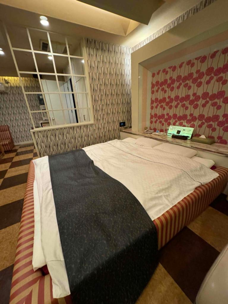 une chambre avec un grand lit dans une pièce dans l'établissement STYLISH, à Kobe