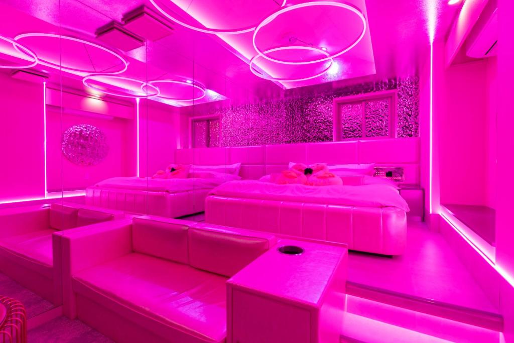 un salon avec un éclairage rose et des canapés dans l'établissement Design Hotel W Zip Club, à Nagoya