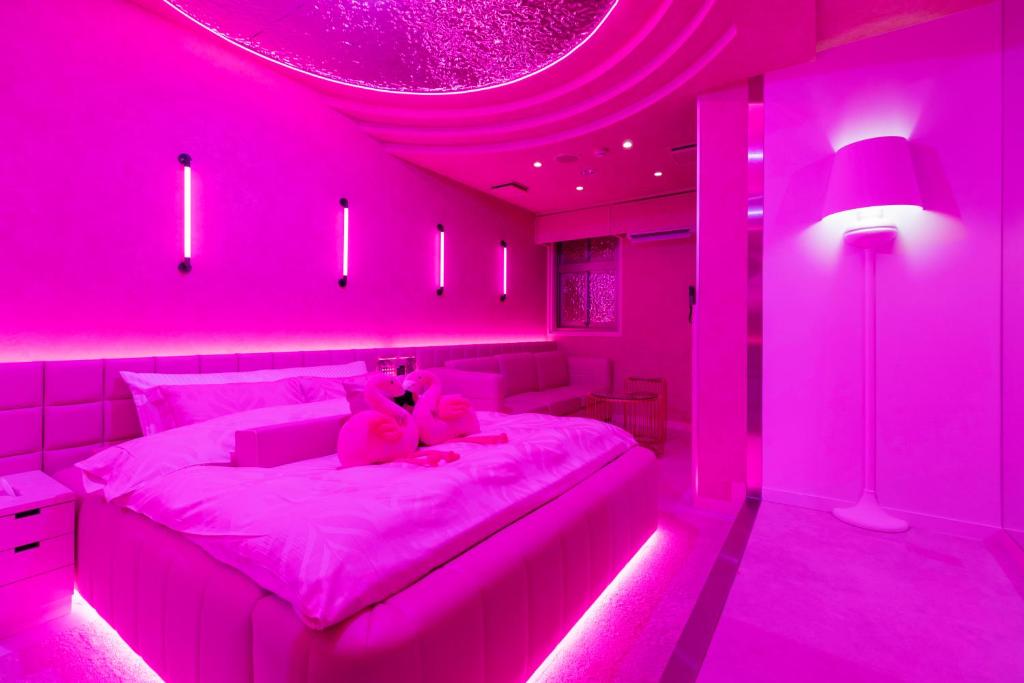 Cette chambre rose comprend un lit avec un ours en peluche. dans l'établissement Design Hotel W Zip Club, à Nagoya