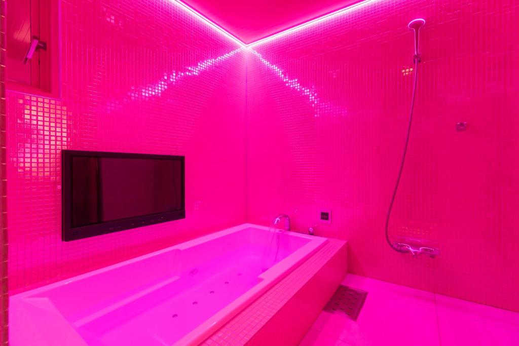 une salle de bain rose avec une baignoire et une télévision dans l'établissement Design Hotel W Zip Club, à Nagoya 68 autres photos