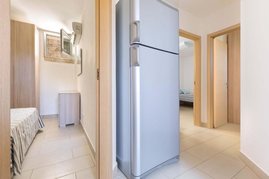 un réfrigérateur blanc dans une pièce avec un couloir dans l'établissement Perla Bianca by Perle di Puglia, à Torre San Giovanni