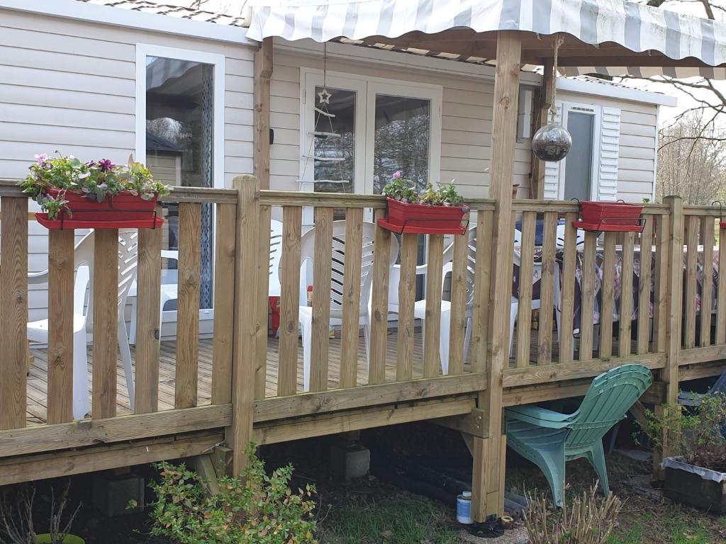 une terrasse en bois avec des plantes en pot et une chaise dans l'établissement Mobile home 6 personnes, à Sainte-Reine-de-Bretagne 2 autres photos