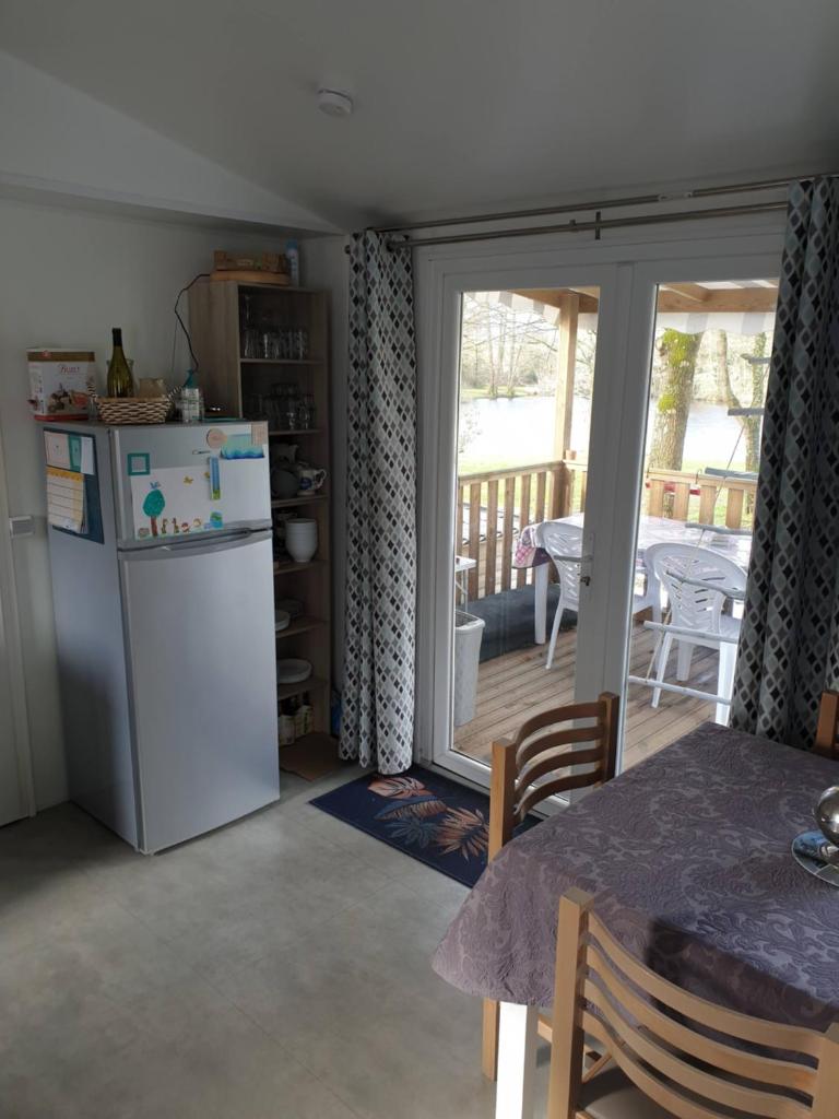 Il comprend une cuisine équipée d'un réfrigérateur et d'une table. dans l'établissement Mobile home 6 personnes, à Sainte-Reine-de-Bretagne