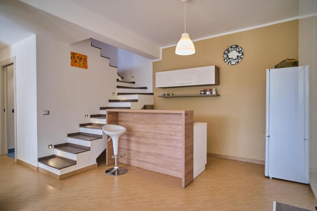 un escalier dans un salon avec un tabouret à côté dans l'établissement Villa Sicilia, à Lascari