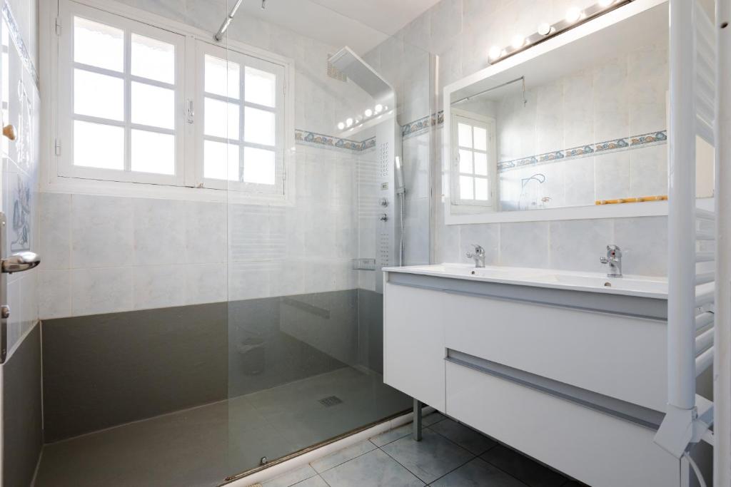 une salle de bain blanche avec un lavabo et un miroir dans l'établissement Grand Chalet St-Lary centre 13 à 15 pers, à Saint-Lary-Soulan 13 autres photos