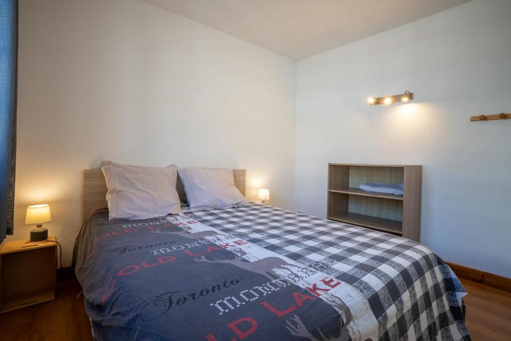 une chambre avec un lit avec une couverture bleue et blanche dans l'établissement Grand Chalet St-Lary centre 13 à 15 pers, à Saint-Lary-Soulan
