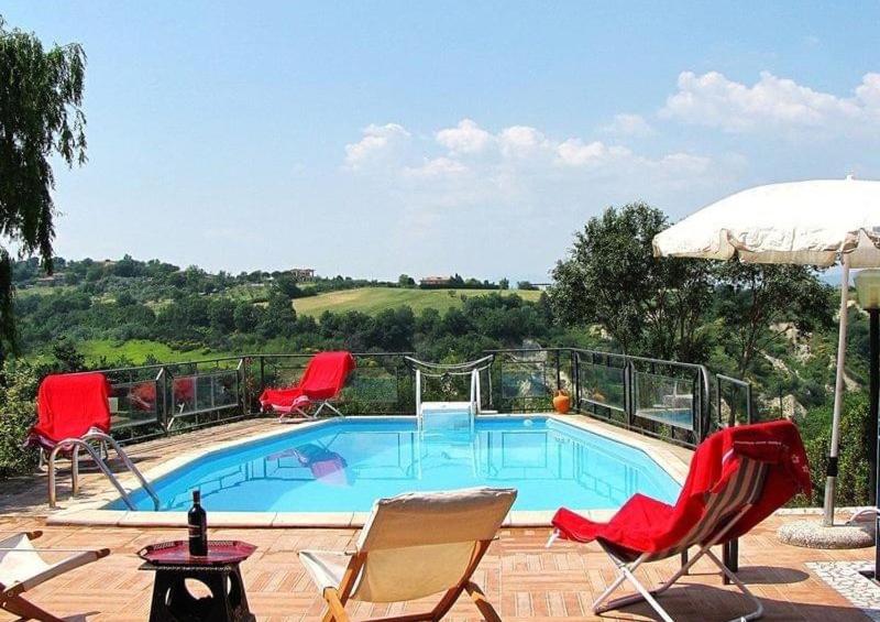 une piscine avec des chaises et un parasol dans l'établissement IL PAGO, à Calvi dellʼ Umbria