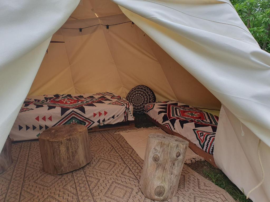 Cette tente comprend 2 lits et 2 bûches. dans l'établissement tipi des apaches, à Moulayrès