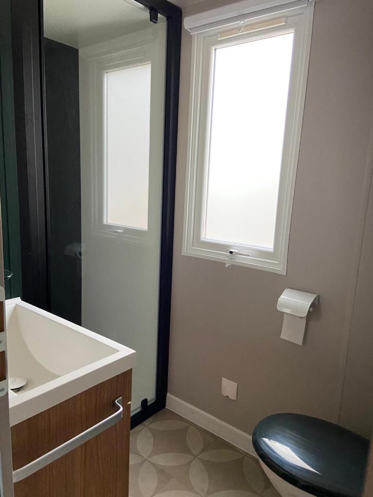 une salle de bain avec un lavabo et des toilettes et une fenêtre dans l'établissement Mobil home Aventura 6-8 personnes tout confort, à Saint-Brévin-les-Pins 22 autres photos