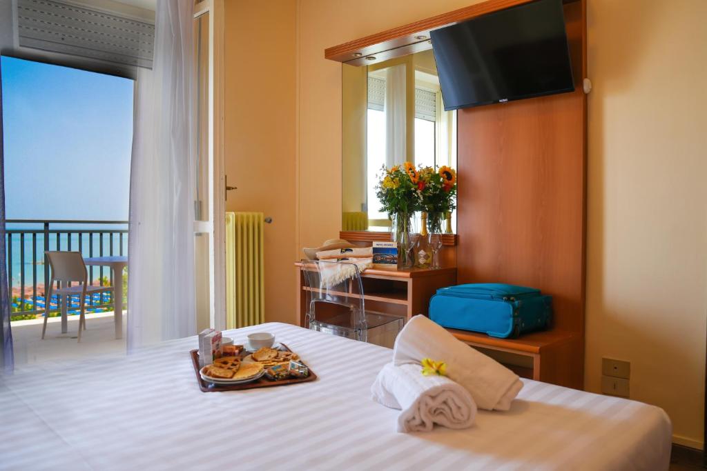 - une chambre d'hôtel avec un lit et un plateau de nourriture dans l'établissement Hotel Regent, à Pescara