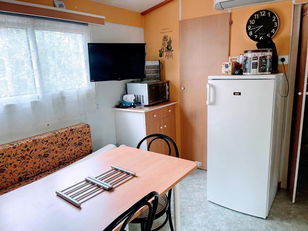 une petite cuisine avec une table et un réfrigérateur dans l'établissement Mobilhome à Sainte Croix Du Verdon, à Sainte-Croix-de-Verdon
