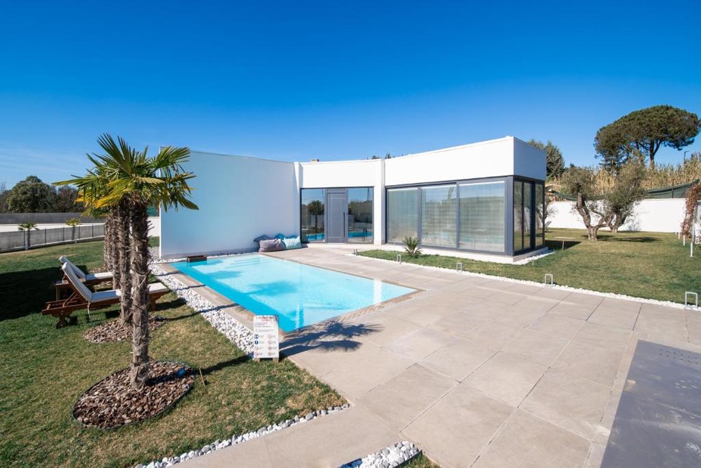 une maison avec une piscine et un palmier dans l'établissement Luxury in the Jungle, à Formello