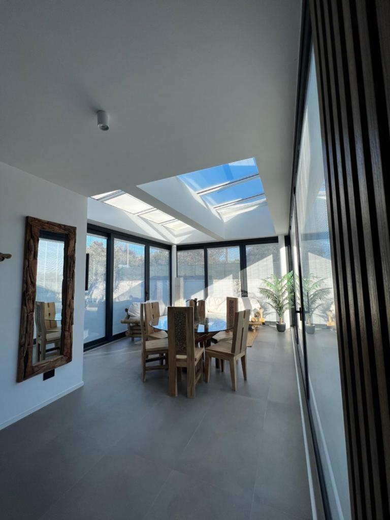 une salle à manger avec une table, des chaises et des fenêtres dans l'établissement Luxury in the Jungle, à Formello