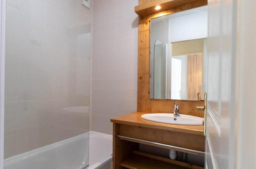 une salle de bain avec un lavabo, une douche et un miroir dans l'établissement APT T2 4 COUCHAGES dans RES. 4 * - BALCONS des AIRELLES (1800) coeur de station, aux Orres 15 autres photos