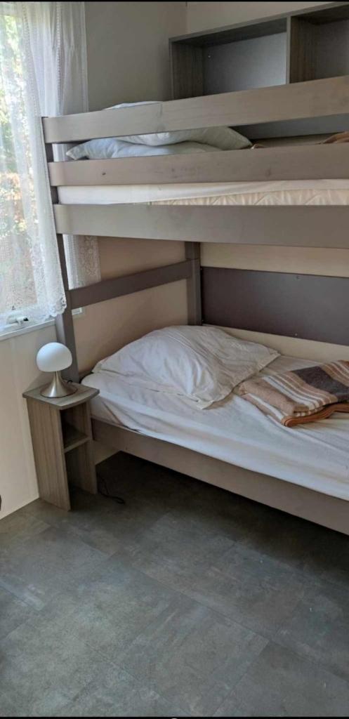 deux lits superposés dans une chambre avec fenêtre dans l'établissement Camping le clos du thym - Argelès-sur-Mer, à Argelès-sur-Mer