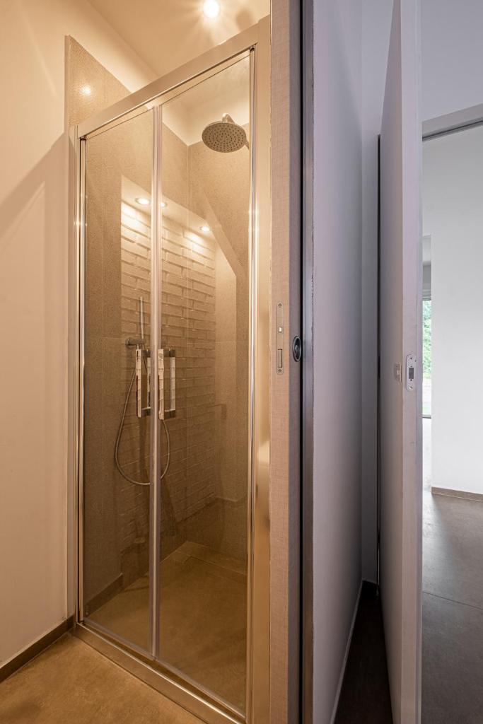La salle de bains est pourvue d'une douche en verre. dans l'établissement Respiro Greco, à Syracuse