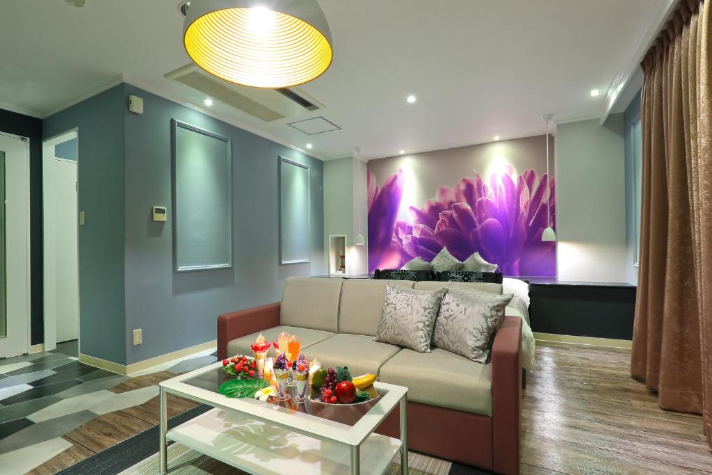 un salon avec un canapé et une table dans l'établissement HOTEL A La Mode -アラモード-, à Utazu