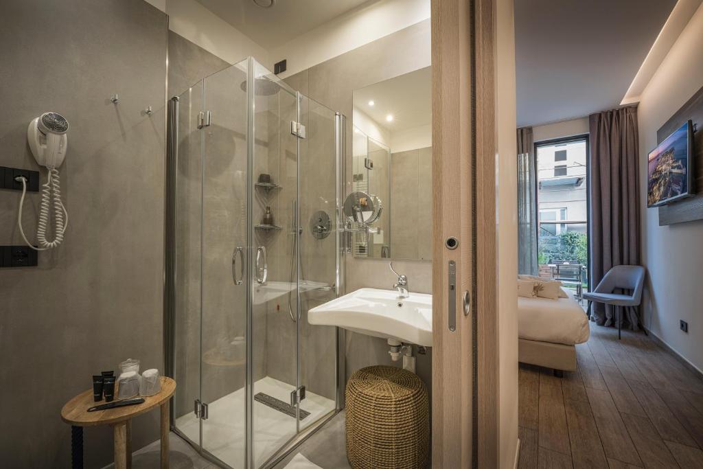 une salle de bain avec une douche en verre et un lavabo dans l'établissement Hotel Vinci, à Sirmione