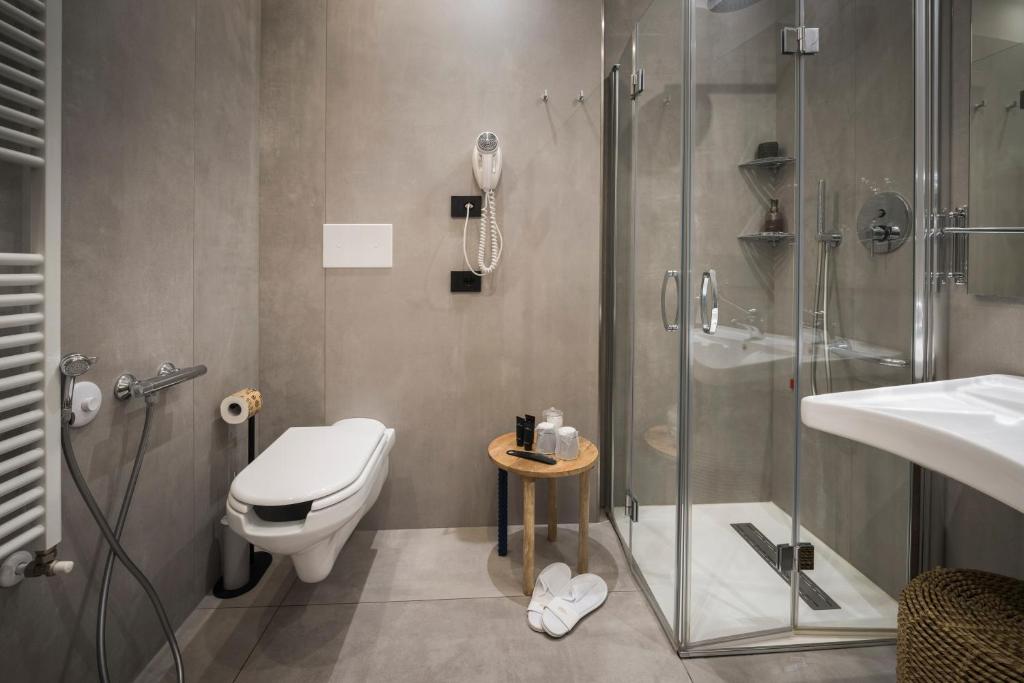 une salle de bain avec une douche, des toilettes et un lavabo dans l'établissement Hotel Vinci, à Sirmione 18 autres photos