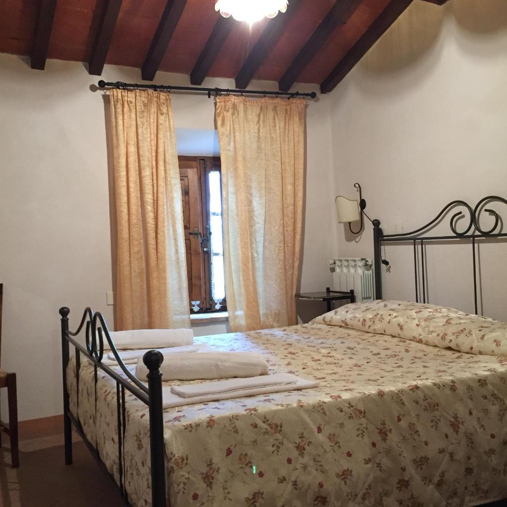 - une chambre avec un lit dans une chambre avec des rideaux dans l'établissement Villa Fonte all'Oppio con area piscina recintata, à Pienza