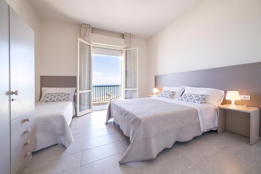 une chambre avec un lit et une fenêtre avec l'océan dans l'établissement Ambasciatori Hotel - Beach Front -Breakfast XXL & Brunch until 12 30pm, à Misano Adriatico
