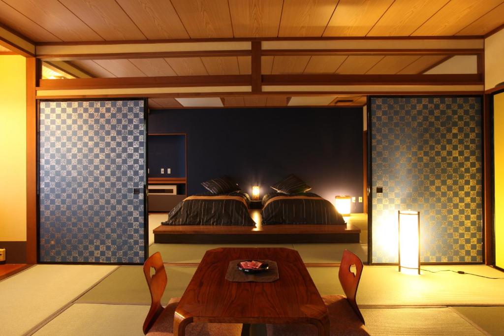 - une chambre avec une table et un lit dans l'établissement Takamiya Ryokan Yamakawa, à Yonezawa