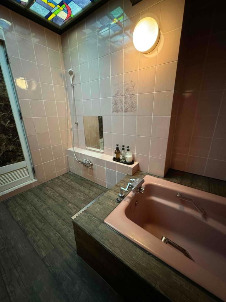 une salle de bain avec une baignoire, un lavabo et un miroir dans l'établissement プラザ太陽, à Ritto