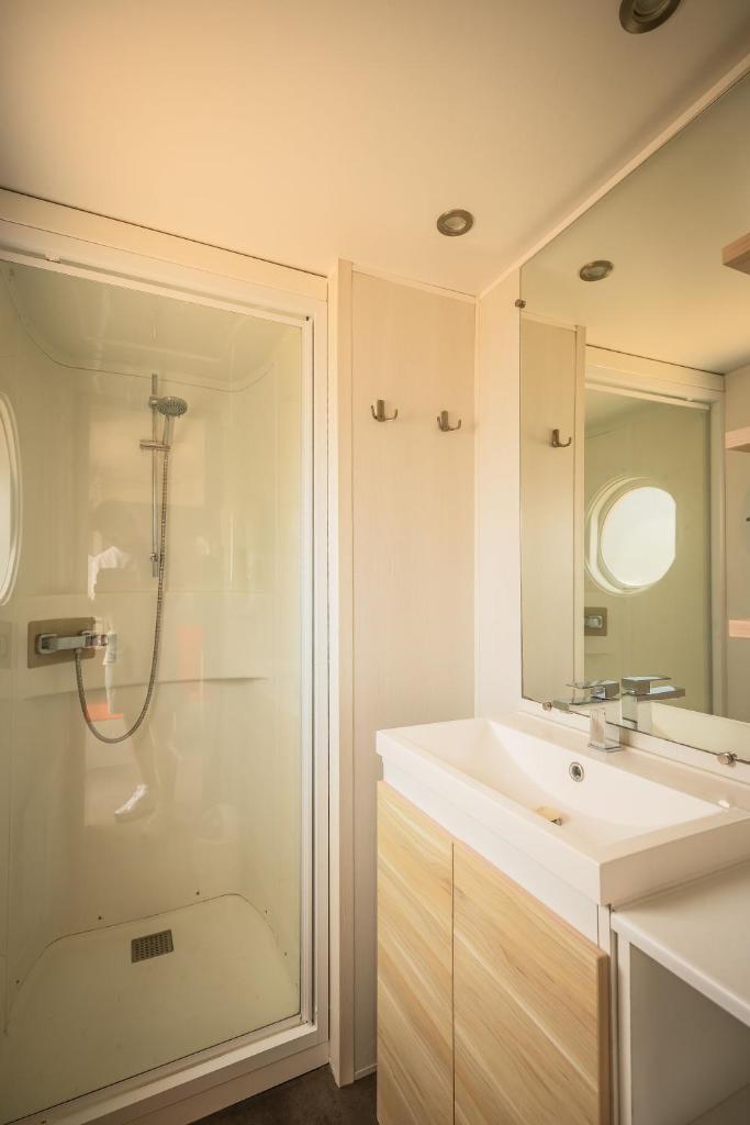 une salle de bain blanche avec une douche et un lavabo dans l'établissement Sauvage, à Quiberon