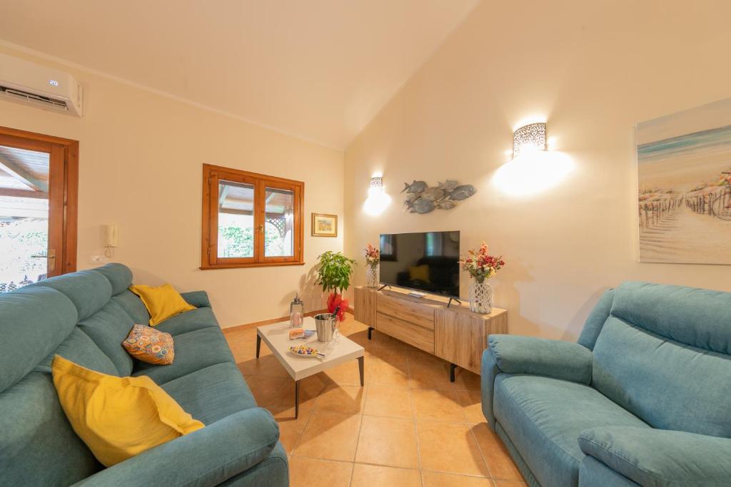 un salon avec un canapé bleu et une télévision dans l'établissement Villa Seaside, à Campofelice di Roccella