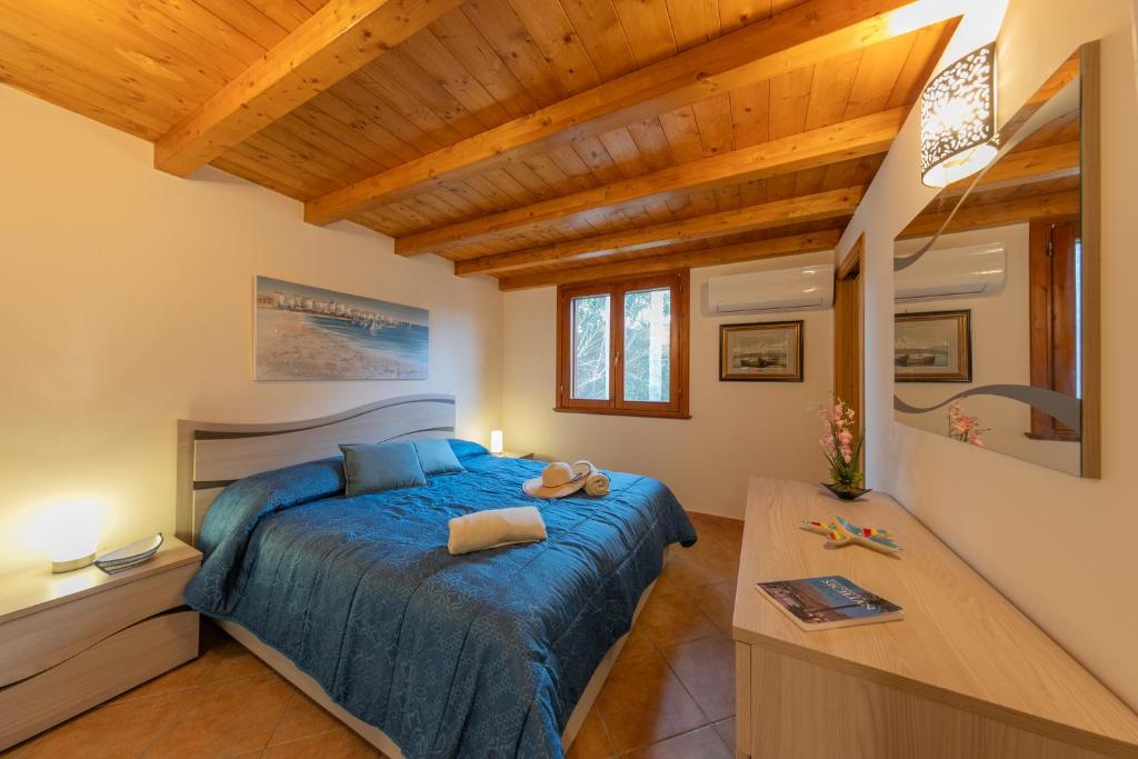- une chambre avec un lit bleu et un plafond en bois dans l'établissement Villa Seaside, à Campofelice di Roccella 48 autres photos