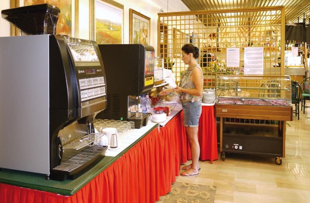 une femme debout à un comptoir dans un magasin dans l'établissement Hotel Bellaria, à Lido di Jesolo