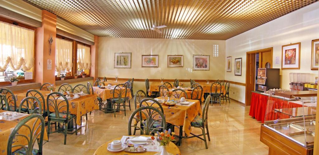 une salle à manger avec des tables et des chaises dans un restaurant dans l'établissement Hotel Bellaria, à Lido di Jesolo
