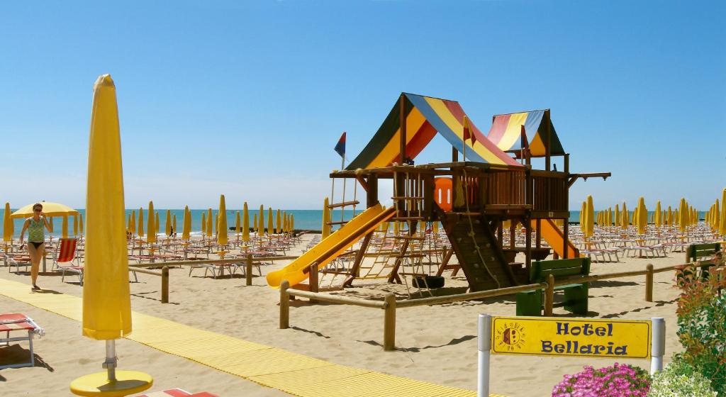 une aire de jeux sur une plage avec des chaises et l'océan dans l'établissement Hotel Bellaria, à Lido di Jesolo