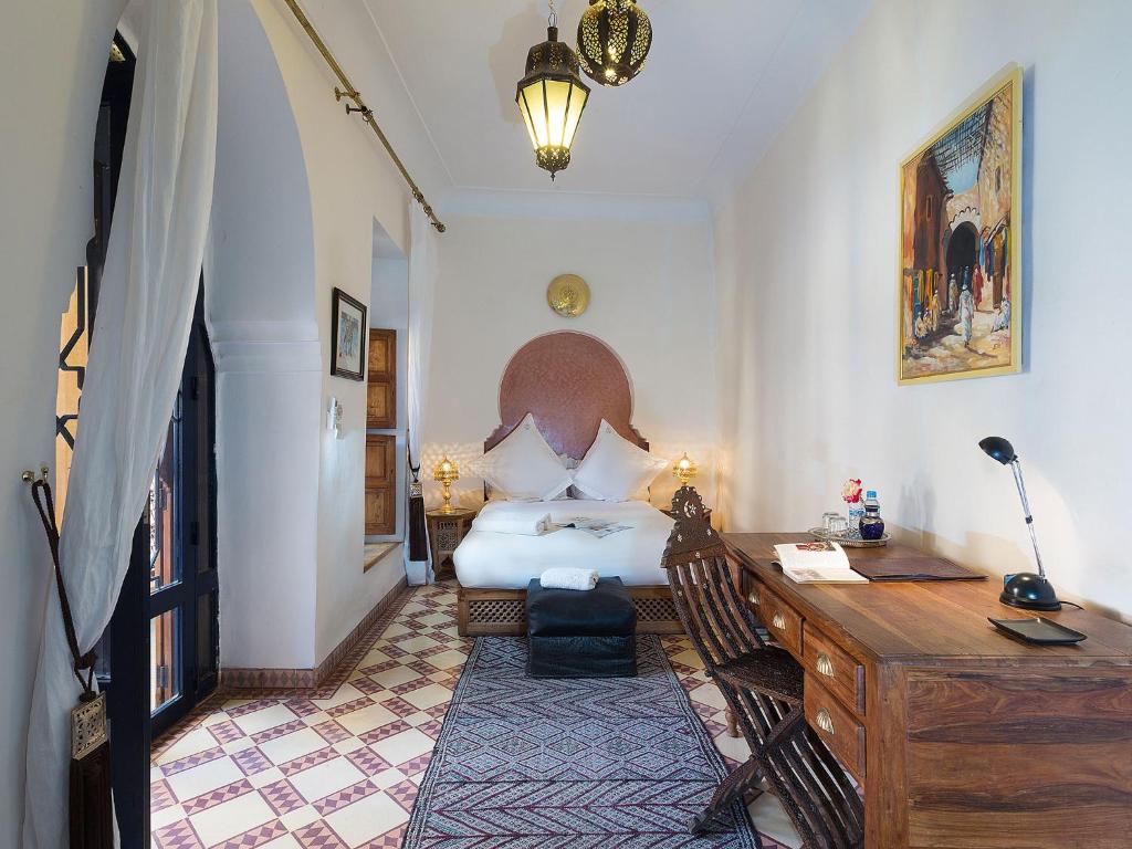 - une chambre avec un lit et un bureau dans l'établissement Riad Soundouss, à Marrakech