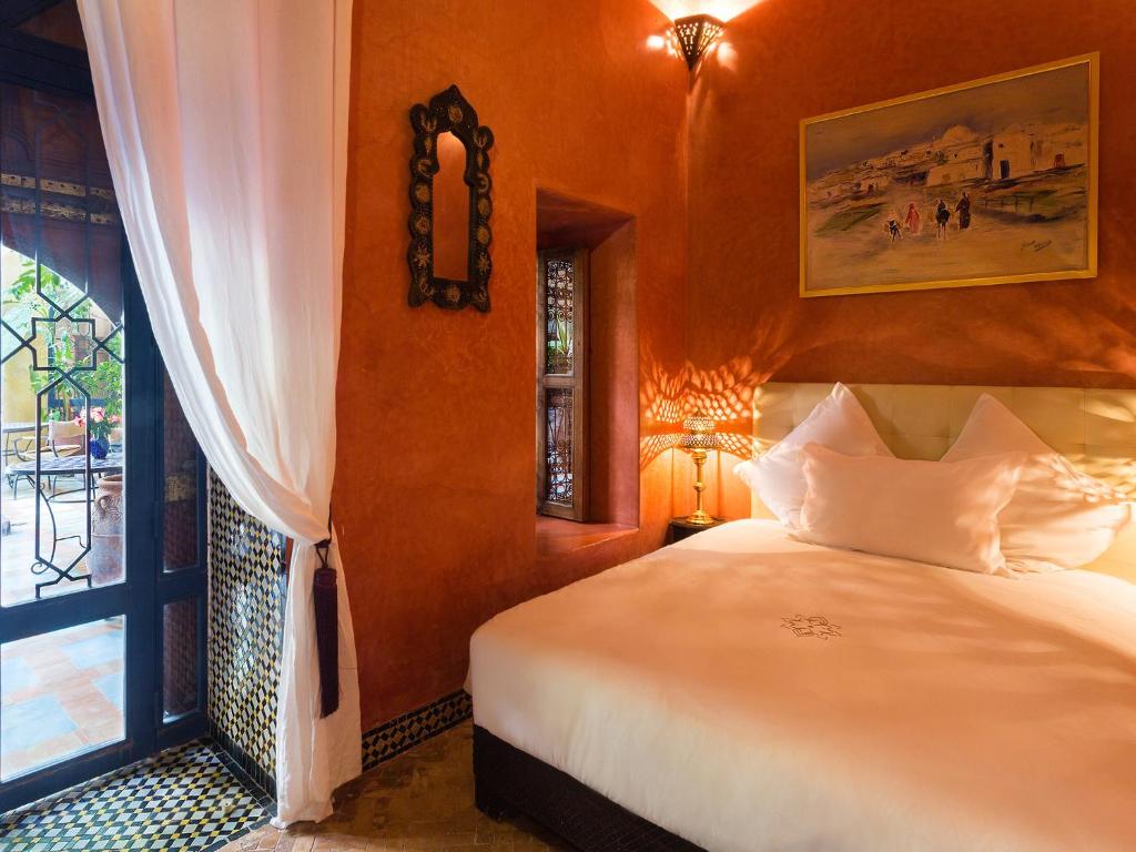 une chambre avec un grand lit et une fenêtre dans l'établissement Riad Soundouss, à Marrakech
